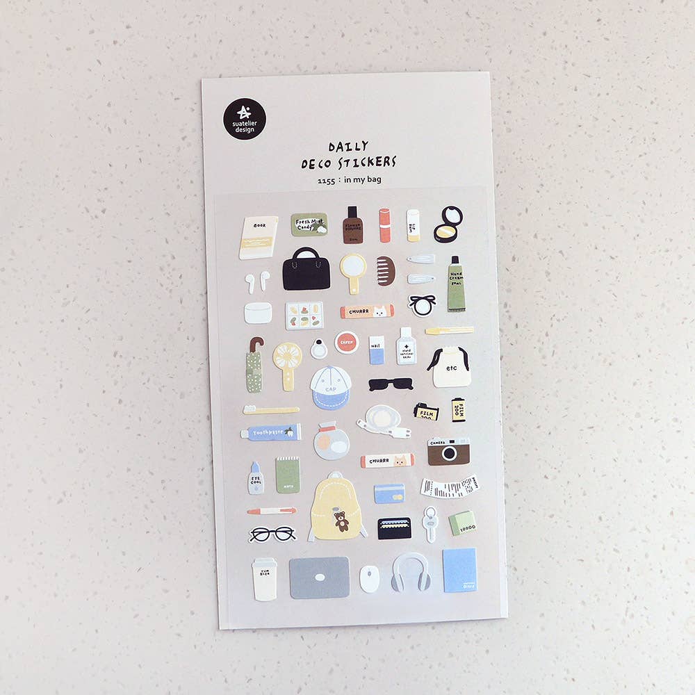 Sheet of decorative stickers with various small illustrations on a textured surface