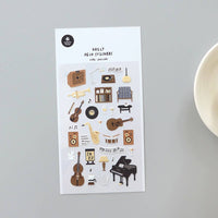 Sheet of decorative stickers with musical instruments and related items on a gray background