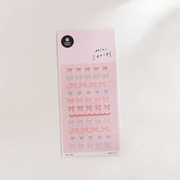Sheet of decorative stickers with bows and hearts on a pink background