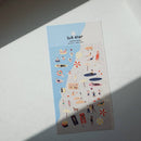 Sheet of decorative stickers with various illustrations on a light surface