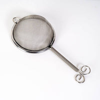 Metallic tea strainer on a white background