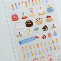 Sheet of decorative stickers featuring cakes, candles, and numbers on a white background.