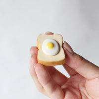 Egg toast ceramic chopstick rest held in a hand