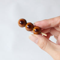 Mitarashi dango ceramic chopstick rest held in a hand
