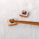 Two ogura toast ceramic chopstick rests, one with chopsticks