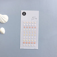 Sheet of decorative stickers with starfish and shell designs on a gray background